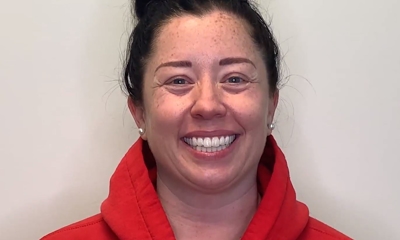 Smiling woman in red shirt against white background, professional headshot for periodontics practice.