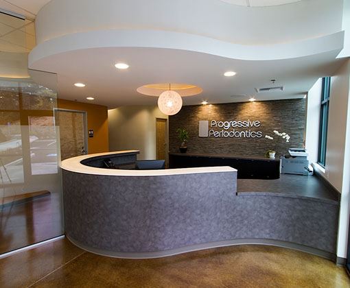 Modern dental office reception area with curved desk and contemporary lighting design.